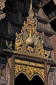 Chiang Mai - The Wat Phan Tao temple, detail of the entrance of the Wihan with the image of a peacock standing over a sleeping dog. 